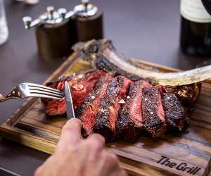 The Grill at McQueen medium rare tomahawk steak off the bone to share
